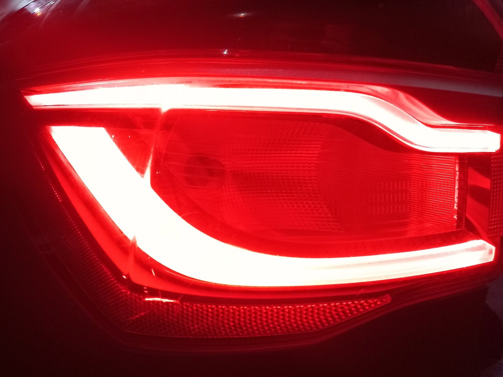 Detalhe de uma lanterna traseira automotiva acesa